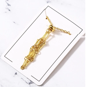 Golden mesh necklace featuring a geometric fringe pendant on a white display card