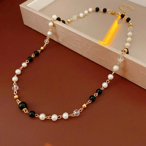 Détail du collier de perles avec fermoir mousqueton doré sur boîte à bijoux