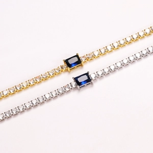 Close-up of tennis bracelets with round cubic zirconia and rectangular blue stones.