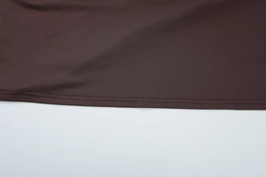 Macro shot of dark brown fabric showing tight knit texture and double-needle stitching