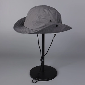 Detail of dark grey sun hat with breathable metal eyelets and adjustable wind strap