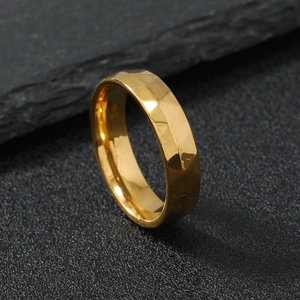 Faceted 6mm gold stainless steel ring for men on a dark slate background