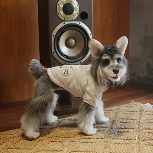 Quilted pet winter coat in cream with embroidery, shown on vintage wooden background