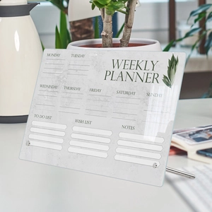 Macro detail of acrylic weekly planner with marble texture and metal stand on a desk