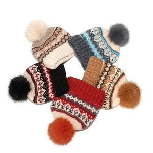 Five Fair Isle knit beanies with geometric patterns and fluffy pom-poms in various colors