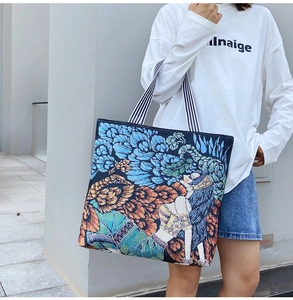 Artistic jacquard tote bag with colorful floral pattern shown on a female model shoulder