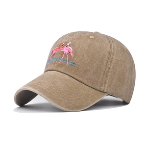 Close-up of flamingo embroidery on vintage washed cotton baseball cap with blue waves