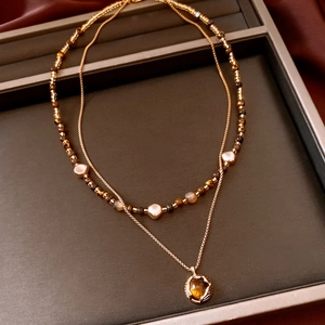 Détail du collier double rang plaqué or 18k avec œil de tigre et perles sur soie