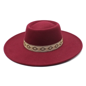 Detail of burgundy wool fedora with gold ethnic embroidered band and wide brim