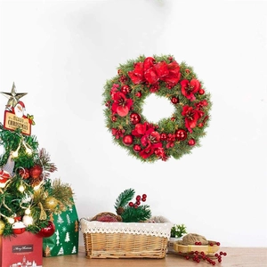 Christmas wreath with red flowers and velvet bow hanging on a white wall for home decor