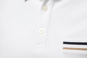 Macro view of white pique cotton polo shirt featuring tri-color ribbon detail on pocket