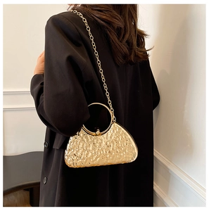 Elegante borsa da sera plissettata oro con manico in metallo e tracolla su modella