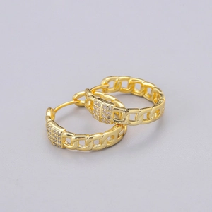 Detailed macro view of gold Cuban chain earrings featuring pave set cubic zirconia crystals