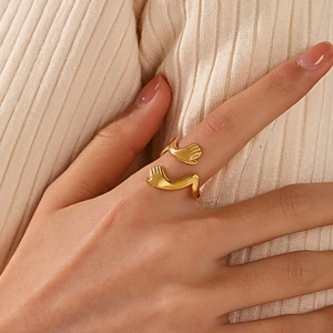 Gold-plated stainless steel hugging hands open ring shown worn on the index finger