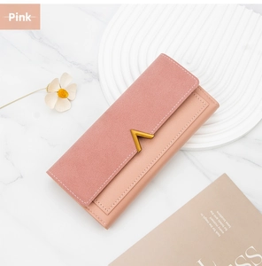 Detail of pink bifold long wallet with gold V-metal buckle on marble surface