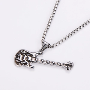 Macro detail of silver stainless steel guitar pendant with flame pattern on chain