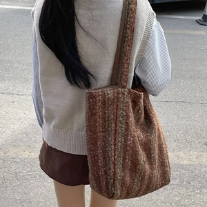 Brown fleece tote bag with retro green stripes shown in a casual outdoor shoulder carry