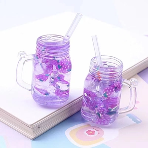 Macro detail of miniature purple mason jar charms with ice cubes and grape decor
