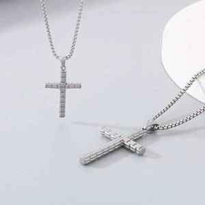 Détail du pendentif croix en acier inoxydable argenté avec relief sur chaîne box