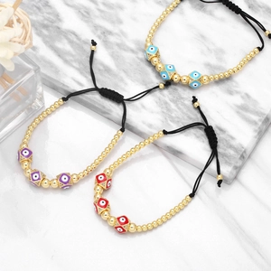Macro shot of three adjustable Evil Eye bracelets with cubic beads on marble background