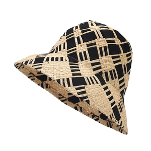 Chic checkered straw sun hat in black and beige woven pattern for beach vacations