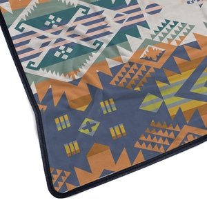 Detail showing the ethnic Aztec pattern flannel blanket with fine dark blue stitched edges
