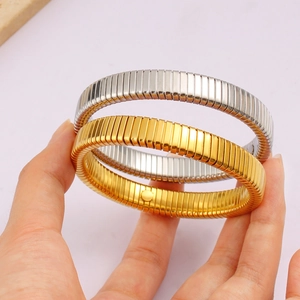 Detail of gold and silver Tubogas stretch bracelets showing ribbed texture and flexibility