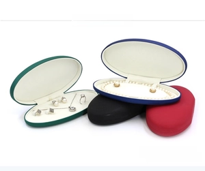 Macro shot of stacking PU leather jewelry boxes with pearl necklace and earring slots