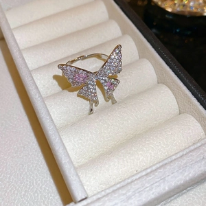 Macro detail of silver butterfly ring with pink zircon and white pave stones