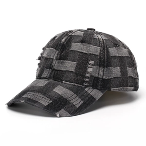Close-up of distressed denim baseball cap with checkered woven texture and frayed edges