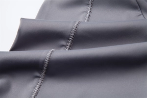 Detailed close-up of grey UV-protection fabric with seamless flatlock stitching finish