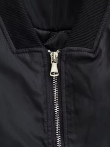 Detailaufnahme der schwarzen Bomberjacke mit Metallreißverschluss und geripptem Stehkragen