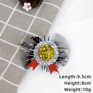 Detail of graduation party hair clip showing 9.5cm length and shiny sequin ribbon textures
