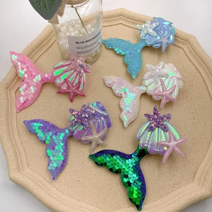 Detail of colorful sequined mermaid tail, seashell, and starfish hair clips for girls