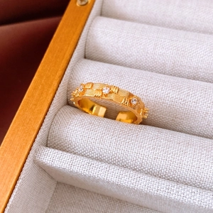Macro shot of gold zircon ring with textured surface on beige jewelry organizer box