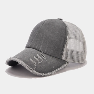 Dettaglio del cappello trucker grigio vintage con rete traspirante ed effetto usurato
