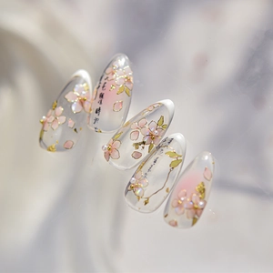 Detailed macro of pink cherry blossom nail stickers with gold foil and pearl accents