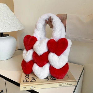 Close-up of plush red and white heart-shaped faux fur tote bag in cozy setting