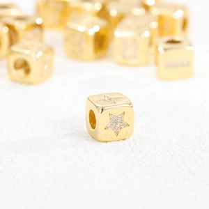 Detailed view of 18K gold plated cube beads with cubic zirconia star patterns for jewelry DIY