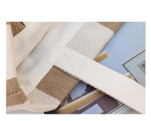 Detail view of woven canvas bag showing sturdy stitching and beige fabric lining texture