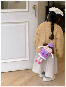 Close-up of a purple crochet doll crossbody bag shown on a child for size and texture