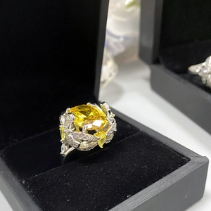 Macro shot of an 18k gold plated ring with a large yellow gemstone in a velvet box