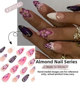 Macro view of 3D floral almond-shaped press-on nails with purple leopard print and shell texture