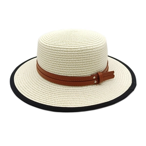 Détail d'un chapeau de paille avec bande en cuir marron et bordure en tissu noir