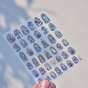 Macro shot of iridescent Gothic cathedral window nail stickers with blue-purple hologram shine