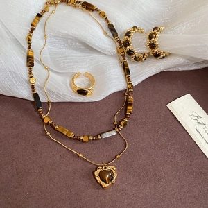 Macro detail of gold tiger eye jewelry set including necklace, ring and earrings
