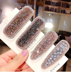 Close-up of four-piece crystal hair clips with sparkling rhinestones and silver beaded edges