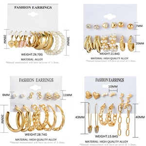 Detailed grid of vintage gold earrings with pearls and heart charms on display cards