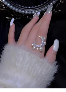 Macro detail of crescent moon ring featuring zircon diamonds and white pearls