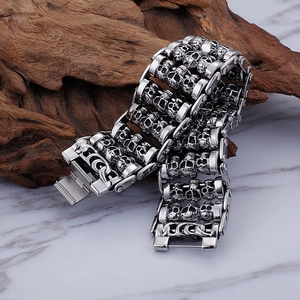 Multi-row punk skull bracelet in stainless steel displayed on vintage wood